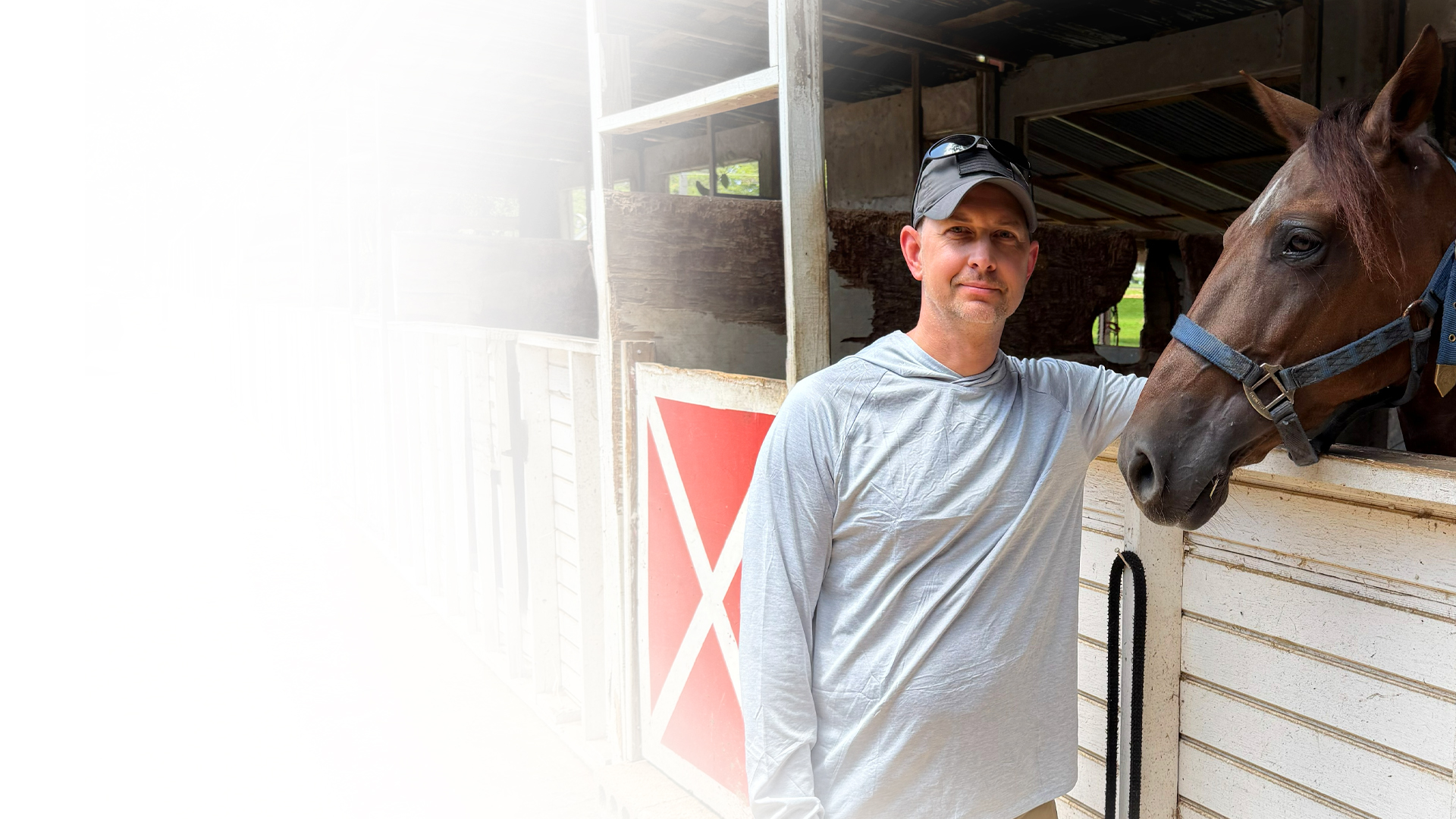 Doug Sahr standing beside a horse in a West Orange County barn